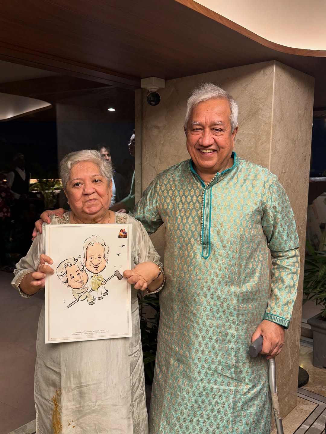 Elderly couple holding a live anniversary caricature of themselves dancing